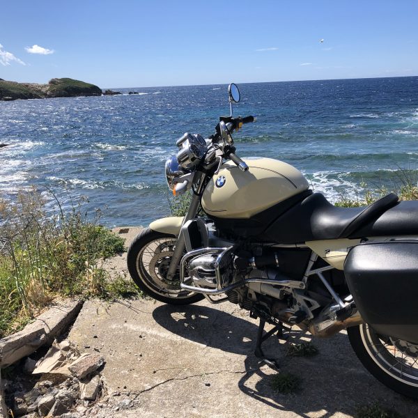 Motorrad an sonniger Felsenküste auf der Insel Korsika.